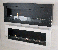 Grote muur-hangende haard in zwart poedercoating staal. Brandtijd 6 uur. Maat: 54 x 136 x 19,8 cm.