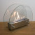Hippe biohaard met rond glas en een stalen brander. Brandtijd 2-3 uur. Maat H: 28 x B: 35 x D: 12 cm.