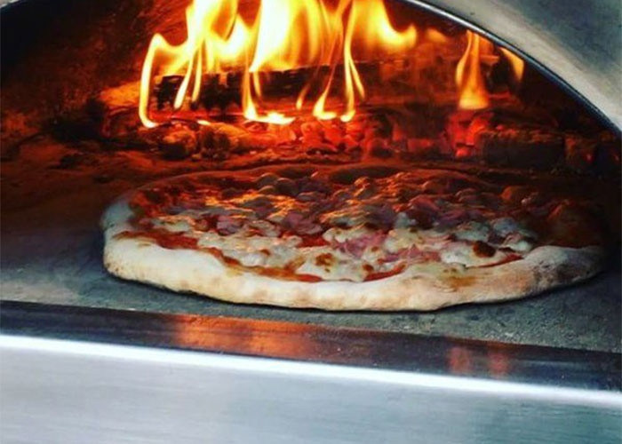 Pizza aan het bakken in de DeliVita buitenoven